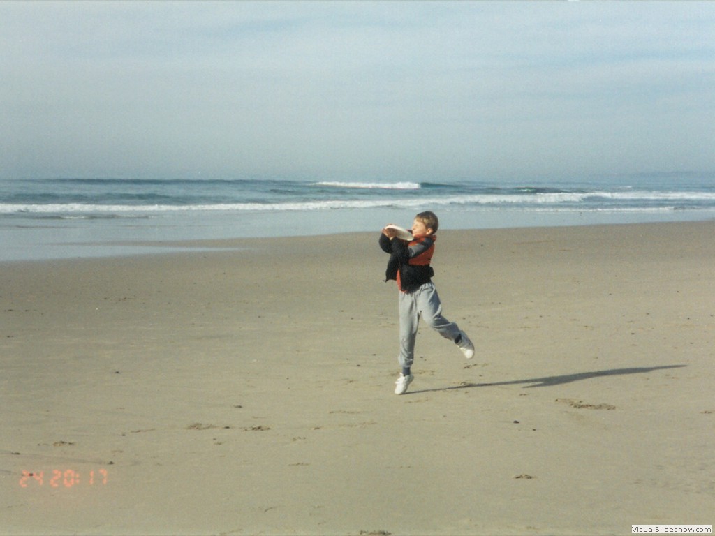 Jason playing frisbee on the beach